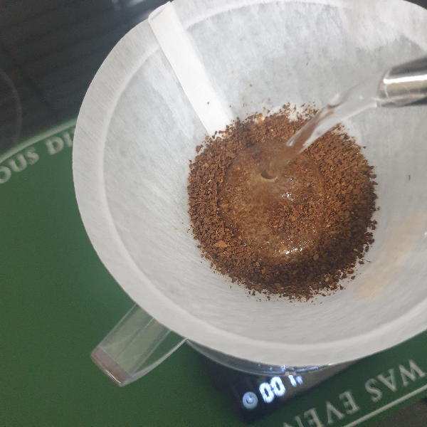 드리퍼 안에 분쇄된 원두가 있고 드립포트로 뜸 들이기를 시작함