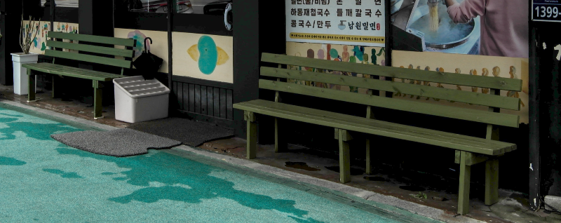 출입문 양 옆 초록색 벵치가 놓여 있다.