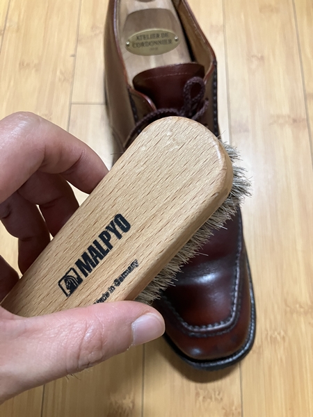 말표 구두솔로 사피르 비즈 왁스 케어 전 브라운 구두의 표면을 가볍게 털어내는 모습