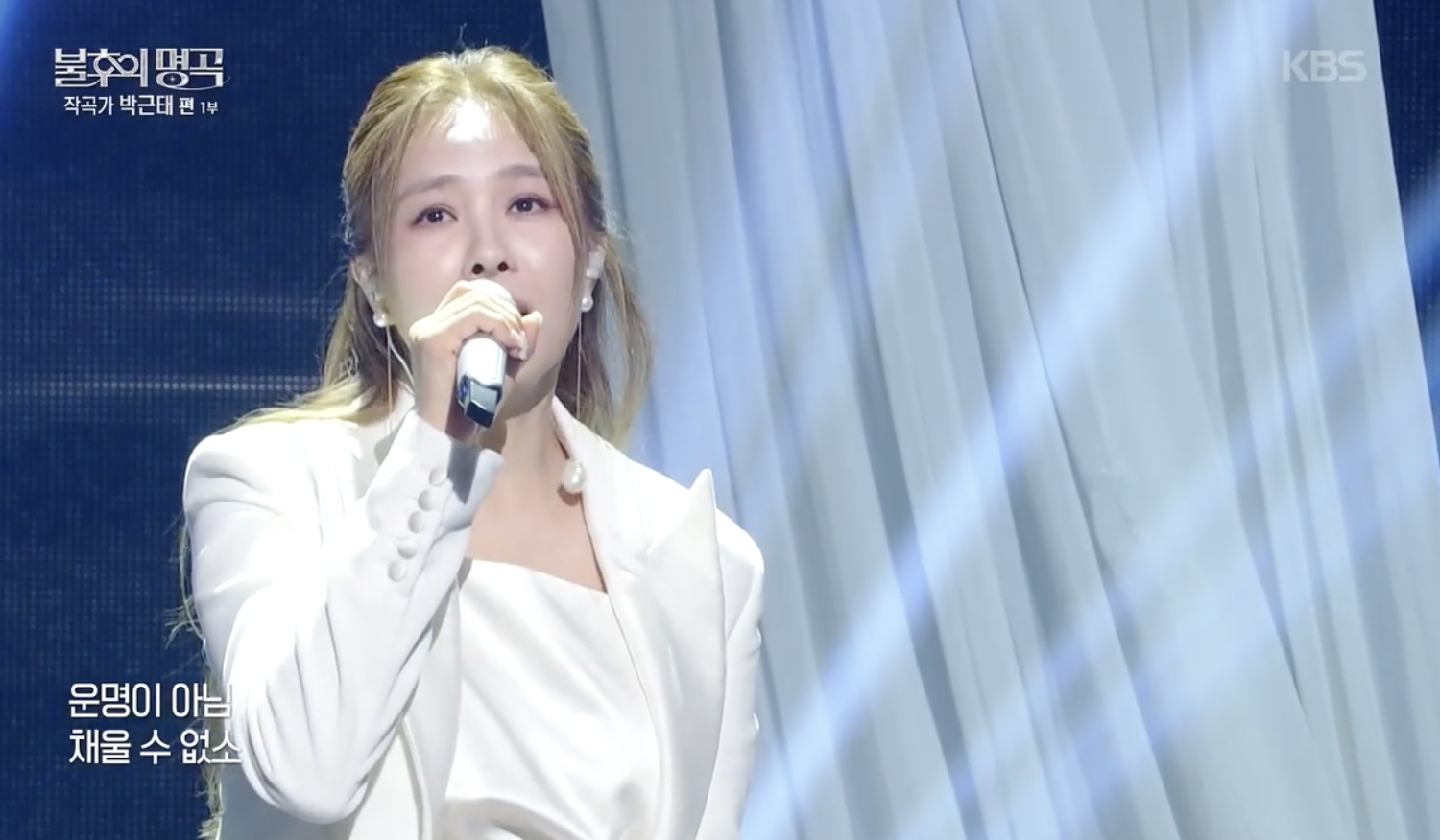 흰 재킷을 입고 마이크를 든 옥주현