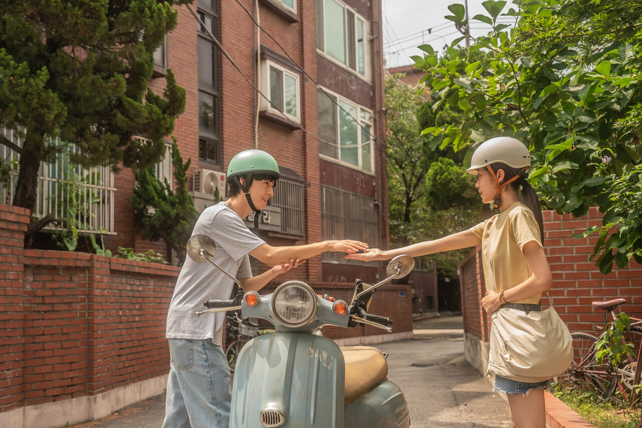 스쿠터를 사이에 두고 손을 잡으려는 용준과 여름