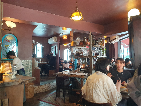 천장과 벽채는 버건디 컬러. 빈티지한 테이블과 의자, 노란 팬던트 조명이 이곳의 분위기를 만든다.