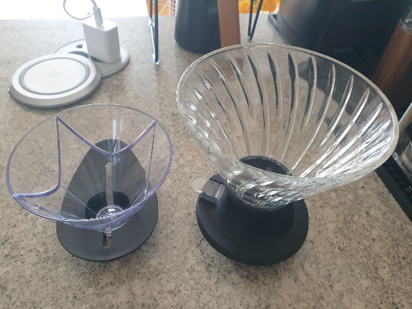 테이블 위에 두 개의 드리퍼. 왼쪽 플라스틱에 작은 드리퍼가 무겐, 오른쪽 유리에 큰 드리퍼가 스위치다.