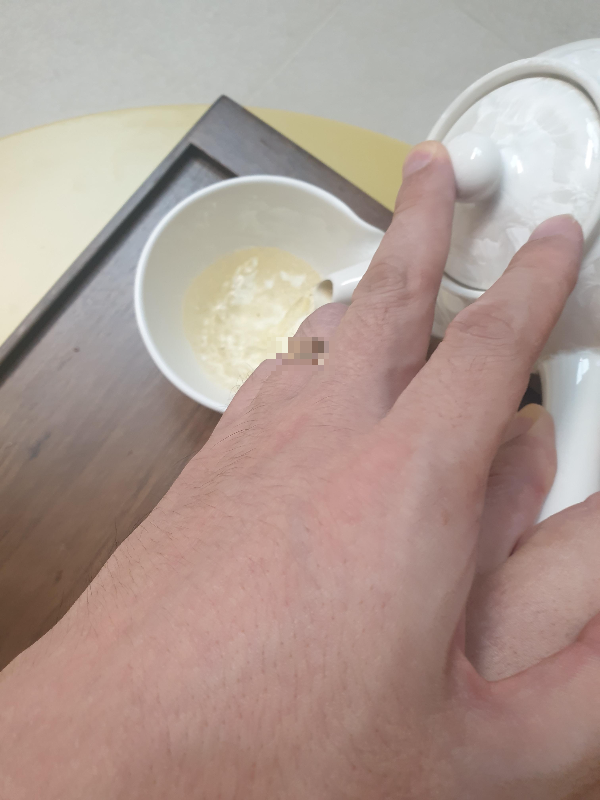 공도배에 차를 따르는 모습. 다완 뚜껑을 손가락으로 고정시키며 따르고 있다.