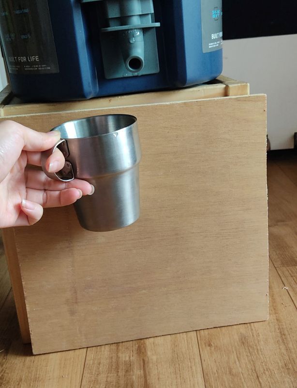 합판을 워터저그 아래쪽과 캠핑컵을 대어보며 크기를 맞추는 모습