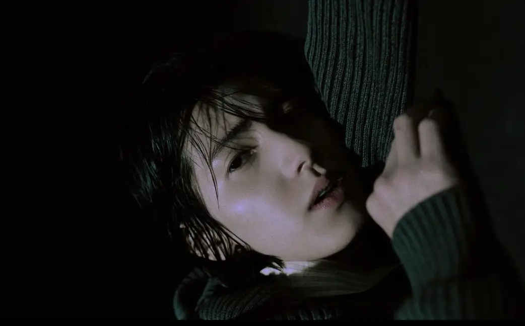 Xdinary-멤버들가 어두운 배경에서 화면을 보고 엎드린채 노래하는 모습