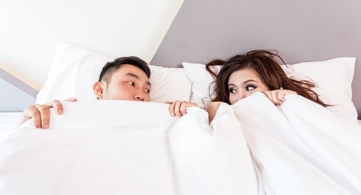 침대위 연인이 누워있는 모습