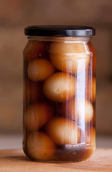 투명한 유리병 안에 식초, 간장, 설탕을 비율에 맞추어 섞은 물에 껍질을 제거한 양파를 통으로 넣은 간장 양파장아찌.
