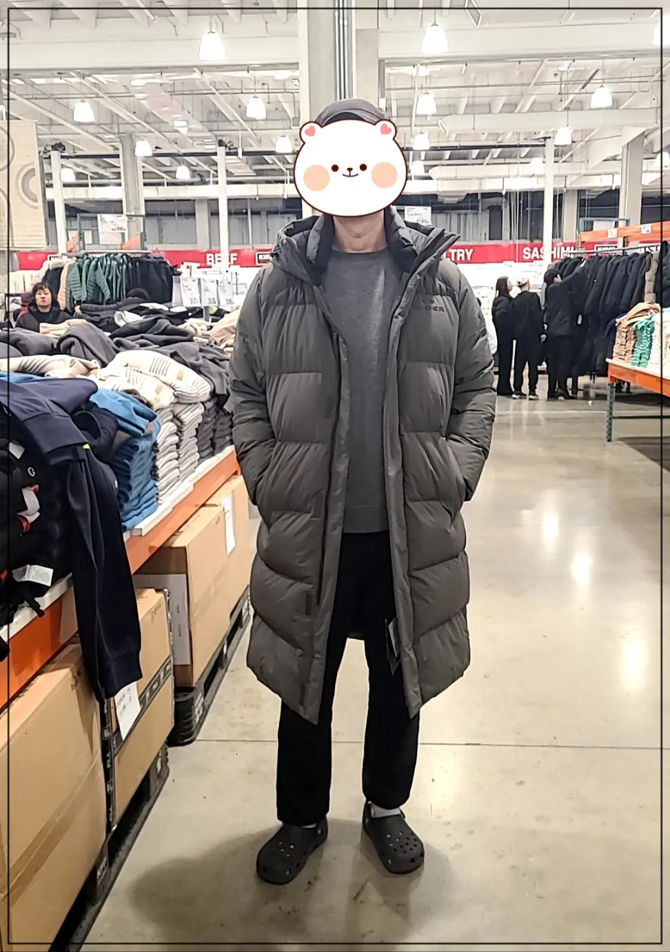 코스트코매장내부 카키색 아이더 롱패딩과 검정모자를 쓴 남성이 서 있는 정면모습