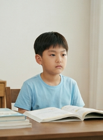 책상 앞에서 멍하니 있는 아이 모습