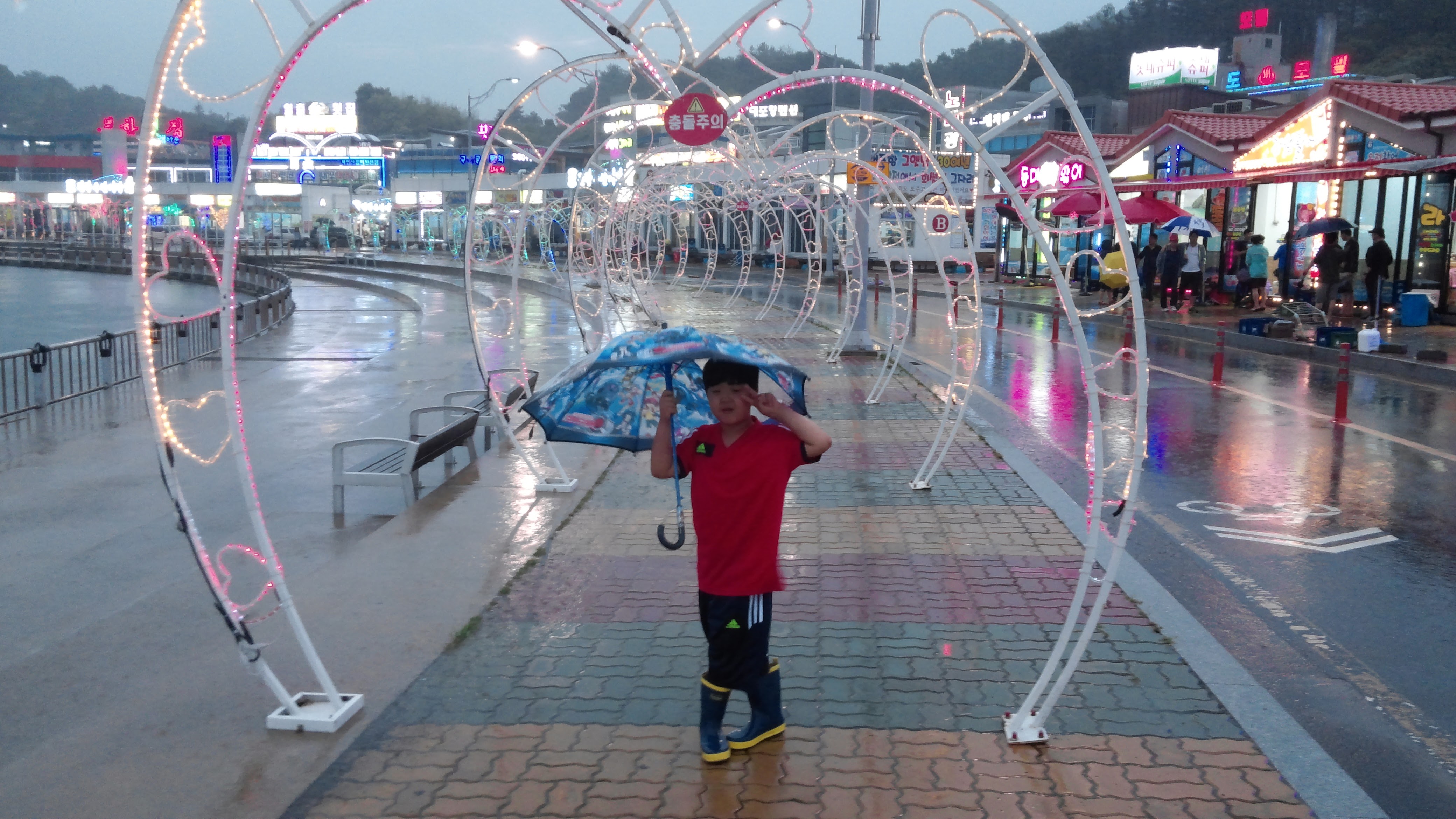 우산을 쓰고 사진 포즈를 잡는 어린이