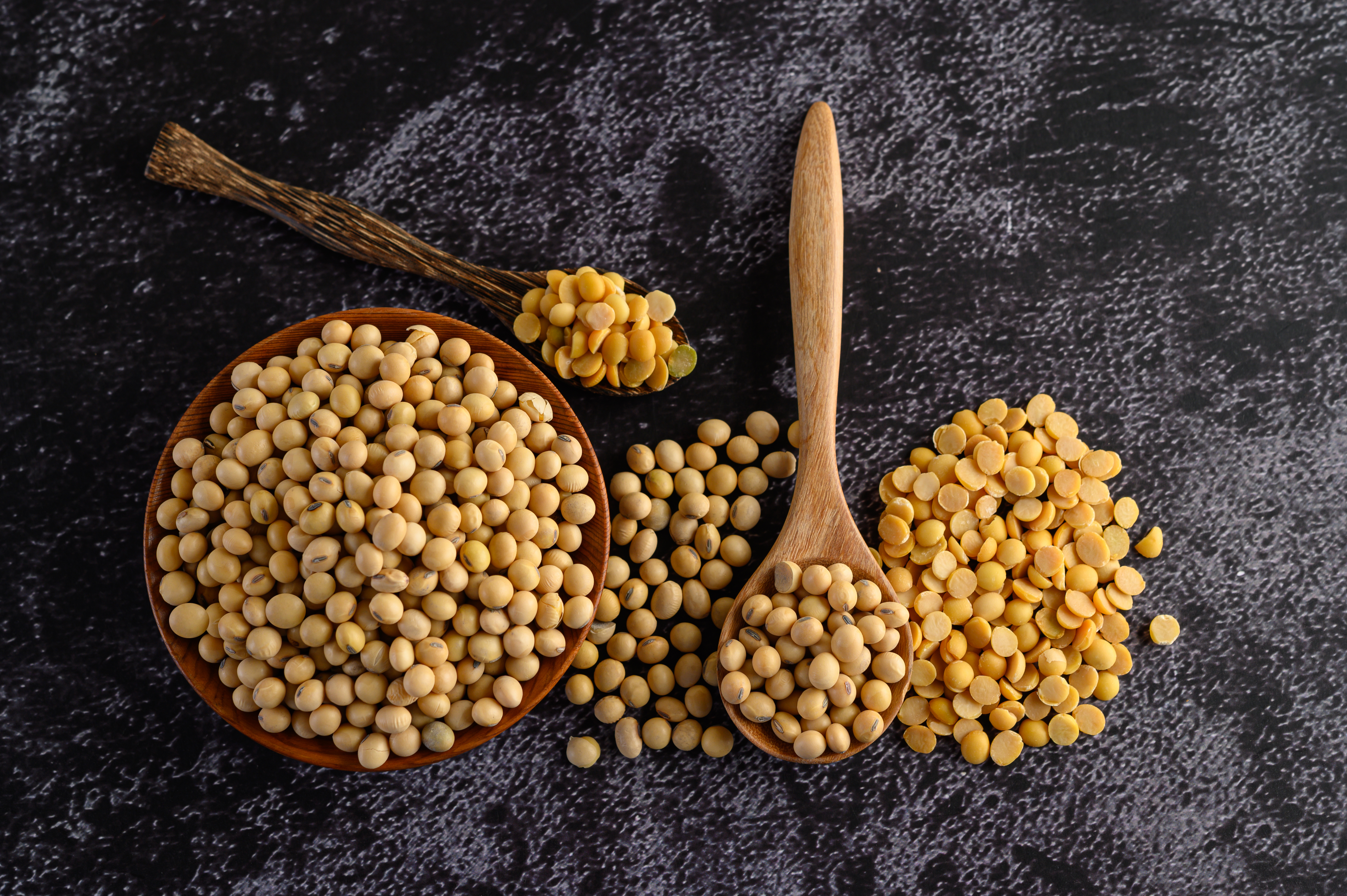 yellow-beans-wooden-bowl-wooden-spoon-black-cement-floor