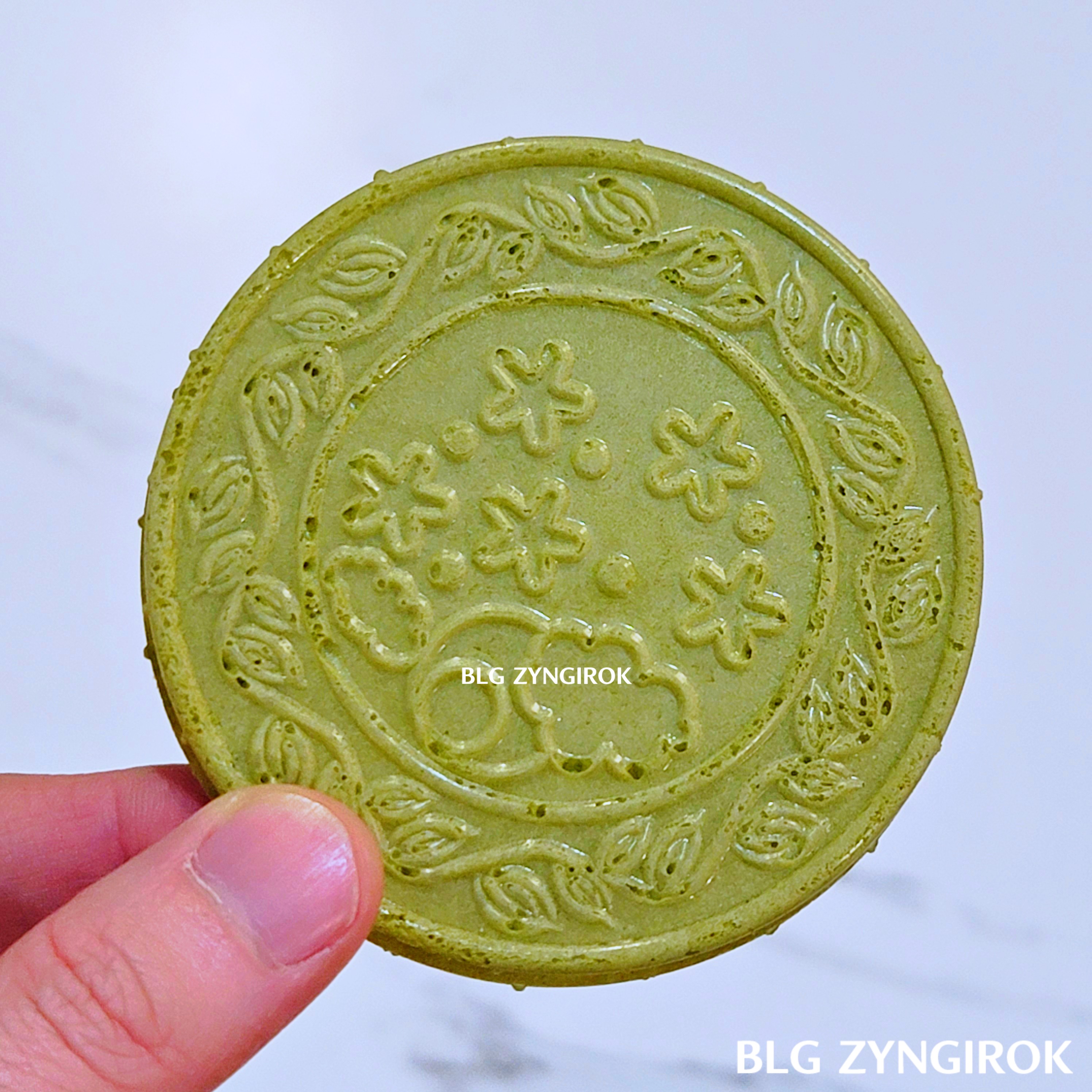 노브랜드 말차 샌드 웨이퍼를 들고 있다. 웨이퍼에 꽃들이 그려진 모습이다.