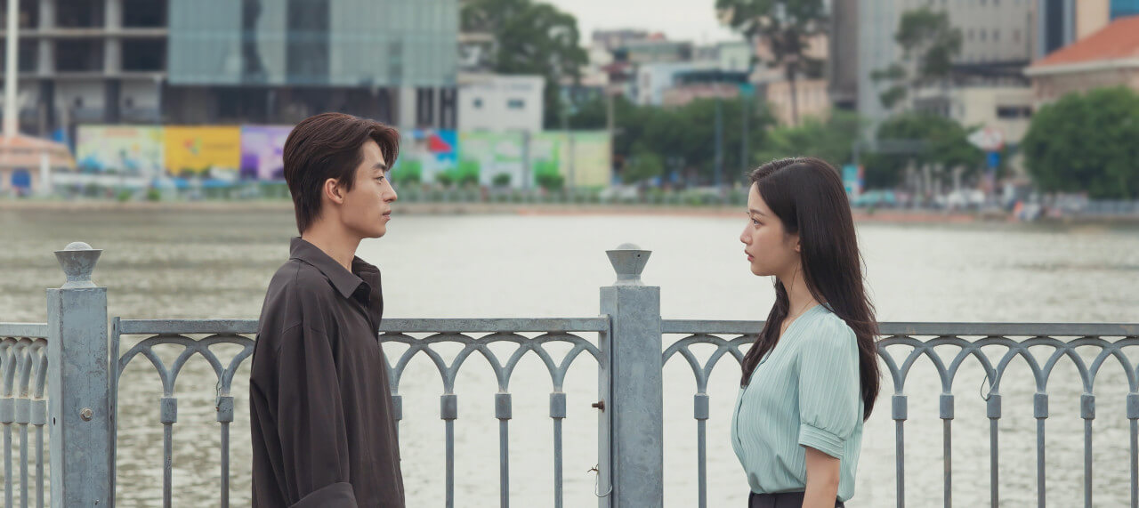 영화 만약에 우리 스틸컷 속 강을 배경으로 서로 마주보고 있는 구교환과 문가영