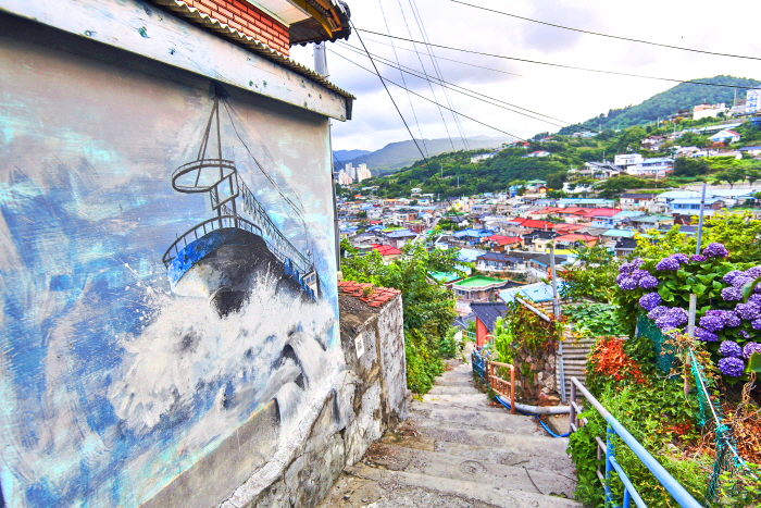 벽화 앞으로 형형색색 지붕의 집들이 있다.