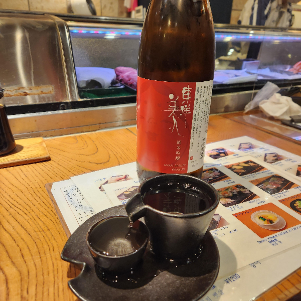 붉은색 라벨이 붙은 사케와 2개의 세케 잔