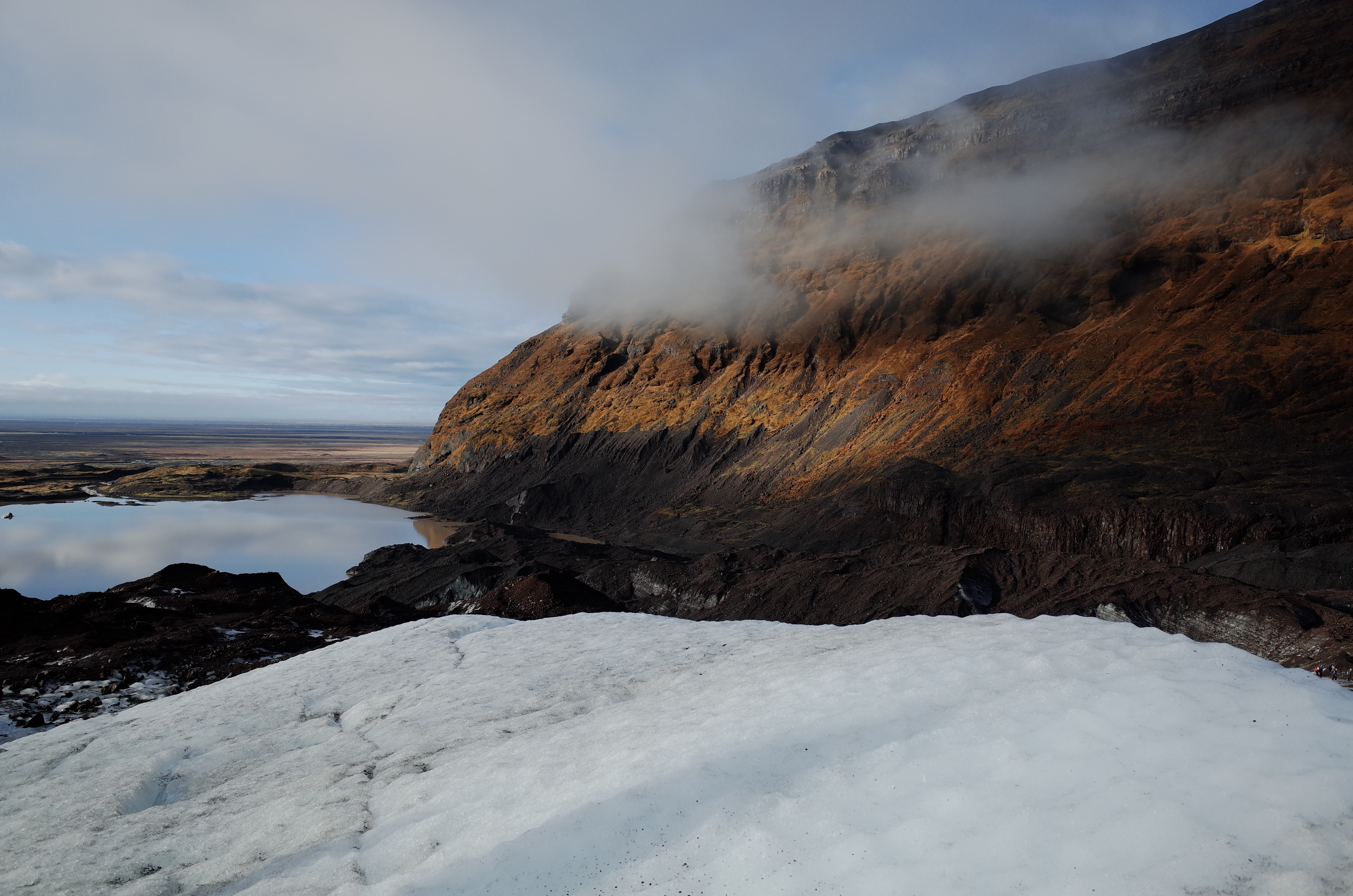 빙하 끝자락에 형성된 빙하 호수와 층암절벽 산맥 전경