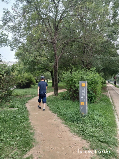 서울 광나루 한강공원 흙길 진입로 – 서울 맨발 걷기 좋은 장소 표지판과 걷는 사람