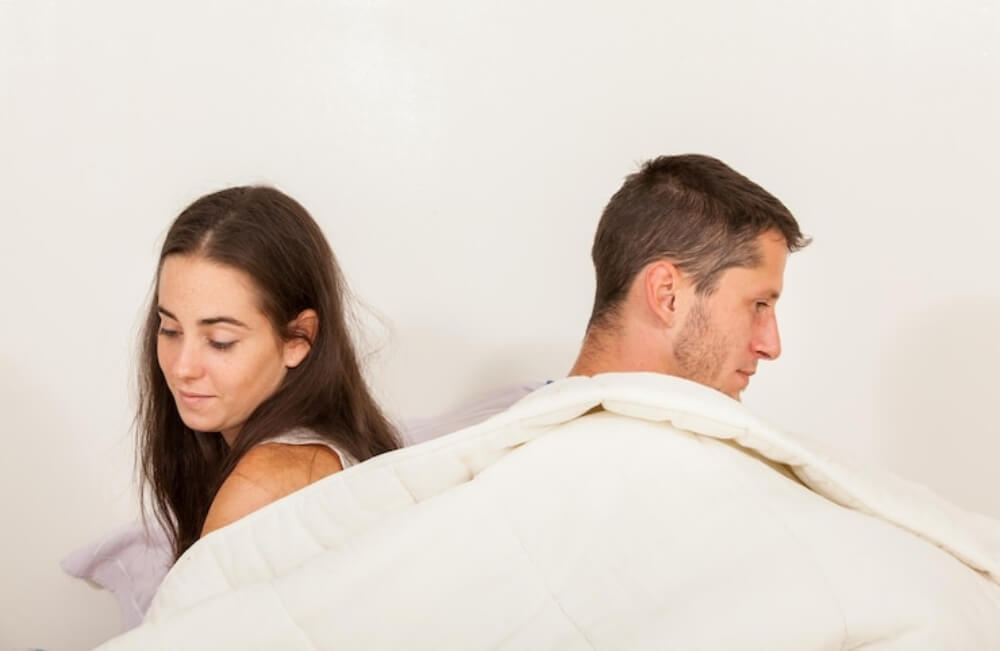 남녀가 침대에서 등지고 있는 모습