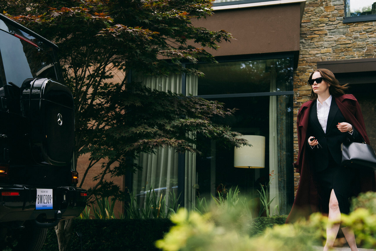 제약회사 CEO인 미셸이 출근을 위해 자신의 집에서 나와 차를 향해 가고 있는 모습