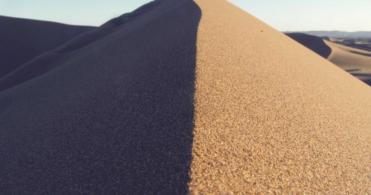 person relaxing on sofa with a book and a cup of tea in a cozy evening atmosphere