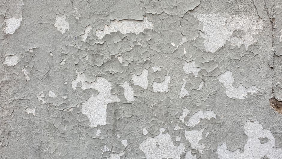 Detailed close-up of a wall with peeling paint, showcasing texture and decay.