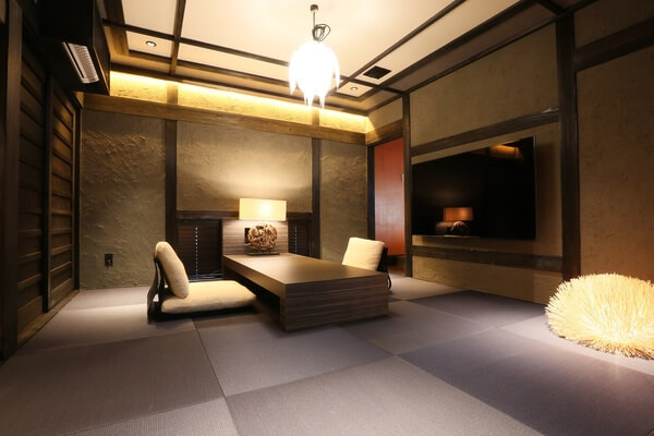 전통적인 일본 다다미 방으로 꾸며진 아늑한 객실. 편안한 좌식 테이블과 따뜻한 조명이 돋보이는 공간