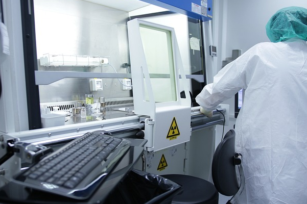 A pharmaceutical company researcher is operating an experimental device.