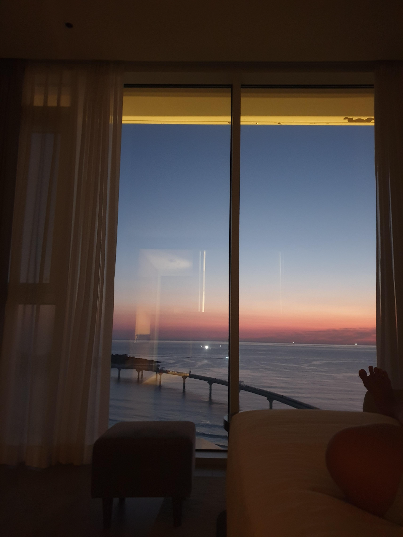 캄캄한 방. 침대 위에서 보는 해돋이. 아직 해가 뜨기 전