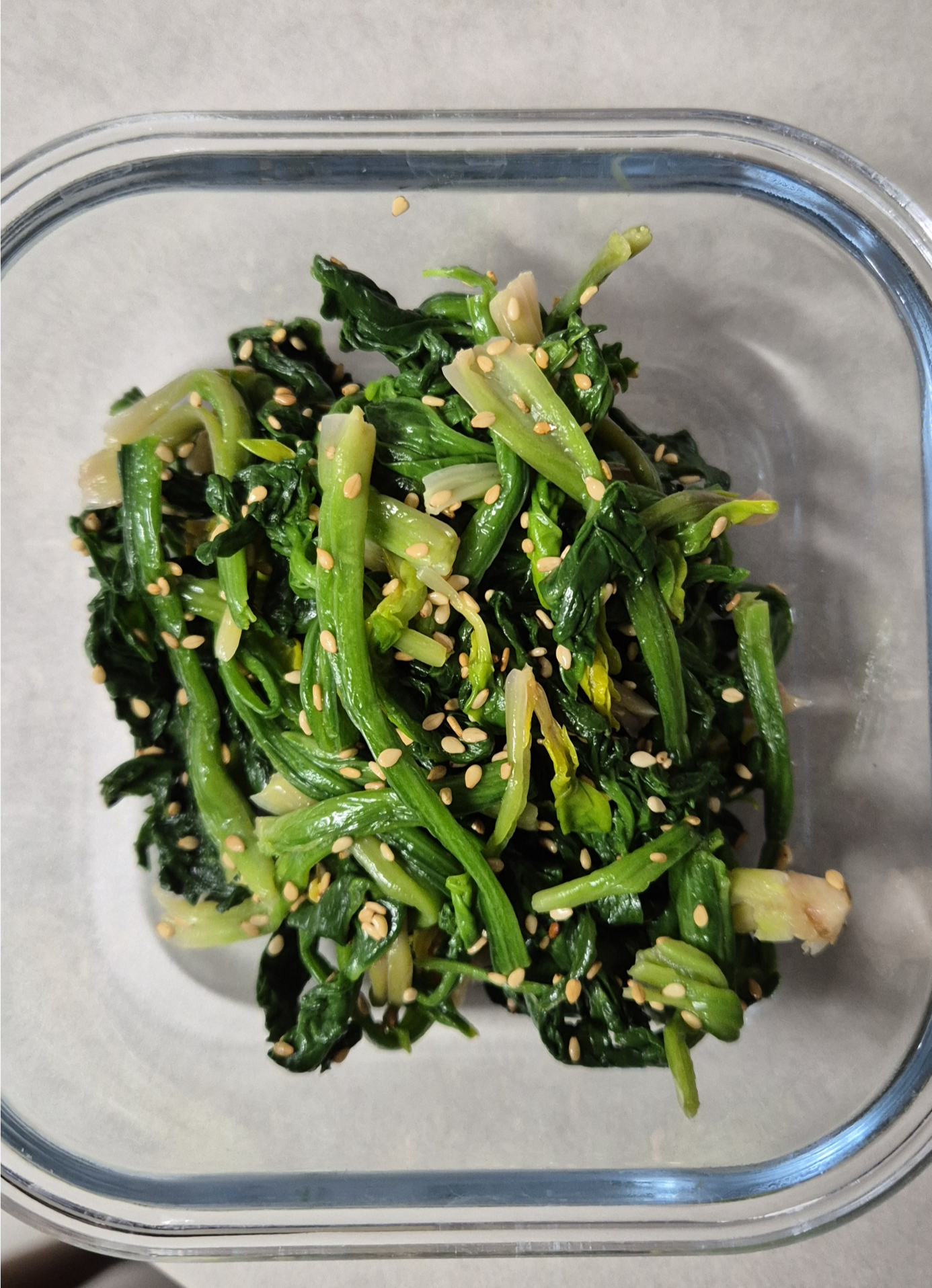 유리 반찬통(글라스락)에 담겨 참깨가 뿌려진 시금치나물 무침 사진