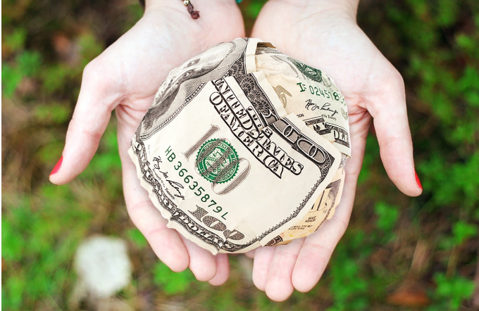 동그랗게 뭉친 지폐를 손으로 들고 있는 이미지로 정부의 지원을 나타냄