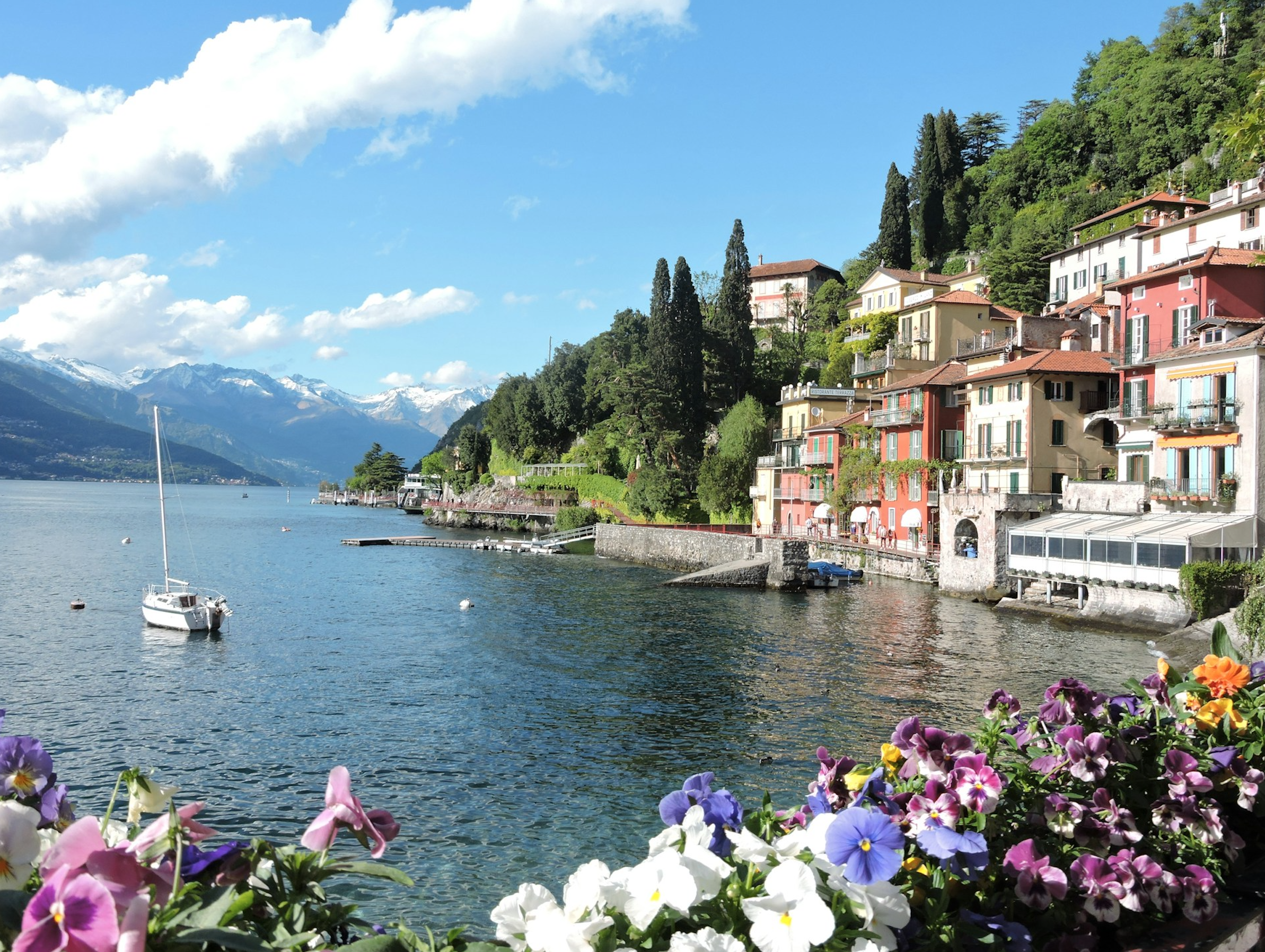 A picturesque view of colorful villas lining the serene shores of Lake Como