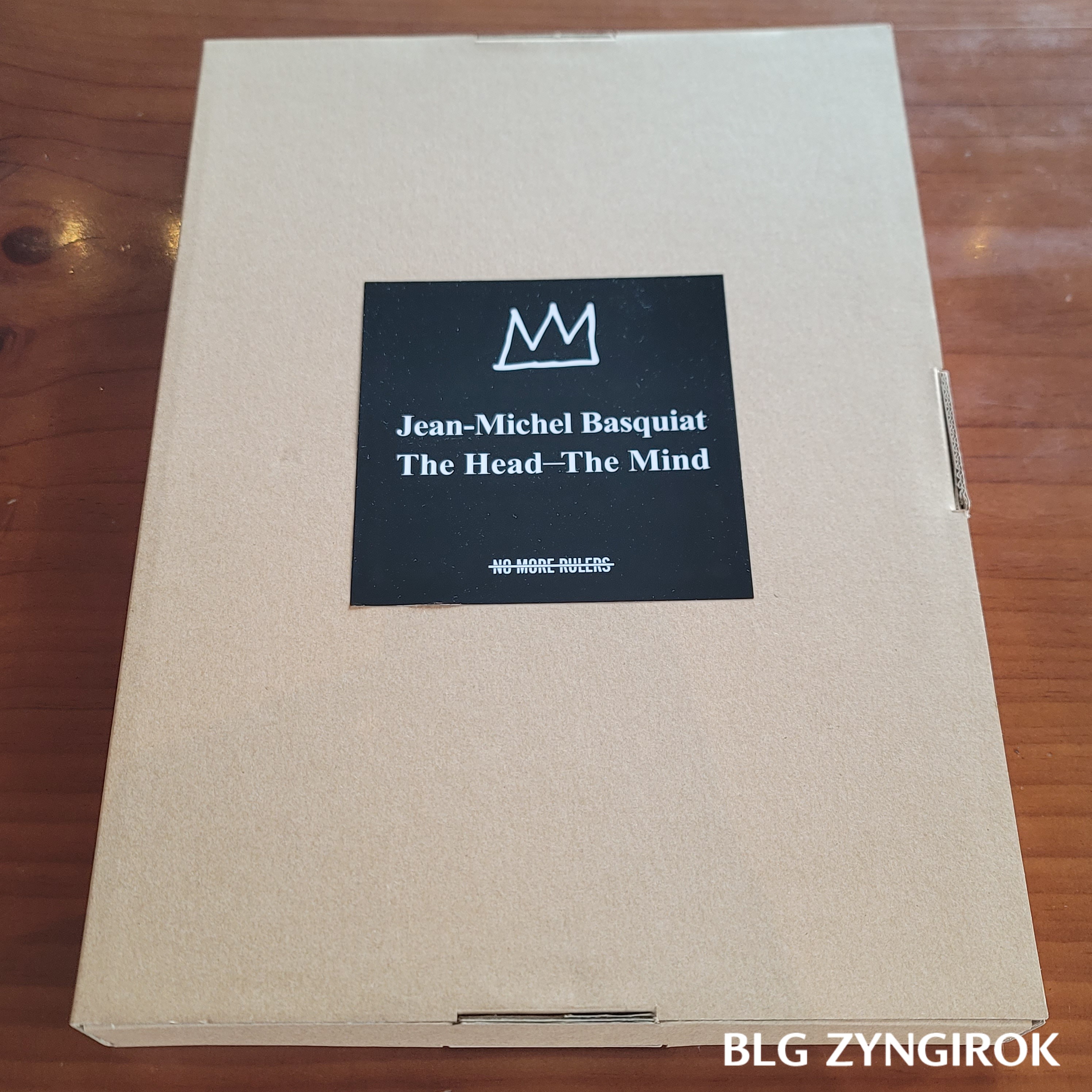 장미셀 바스키아 - 과거와 미래를 잇는 상징적 기호들 도록 상자가 테이블 위에 놓여있다.