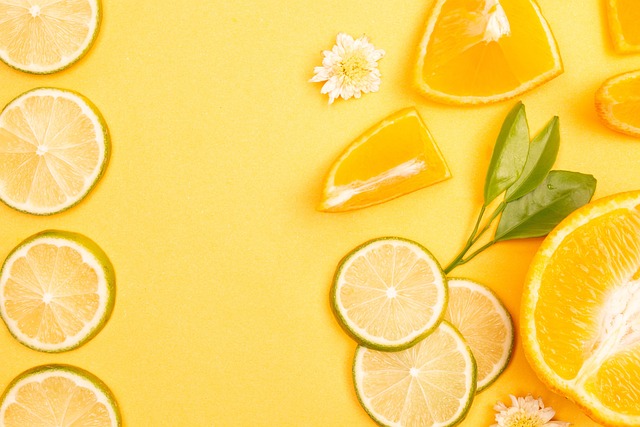 노란색 배경에 레몬 조각이 여러 개 올려져 있고 한 두개 의 흰색 꽃송이가 올려져 있음