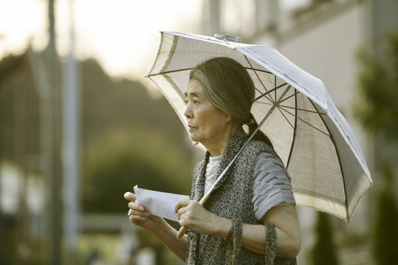 영화 속 할머니 하츠에가 돈봉투를 받고 걸어가고 있는 모습