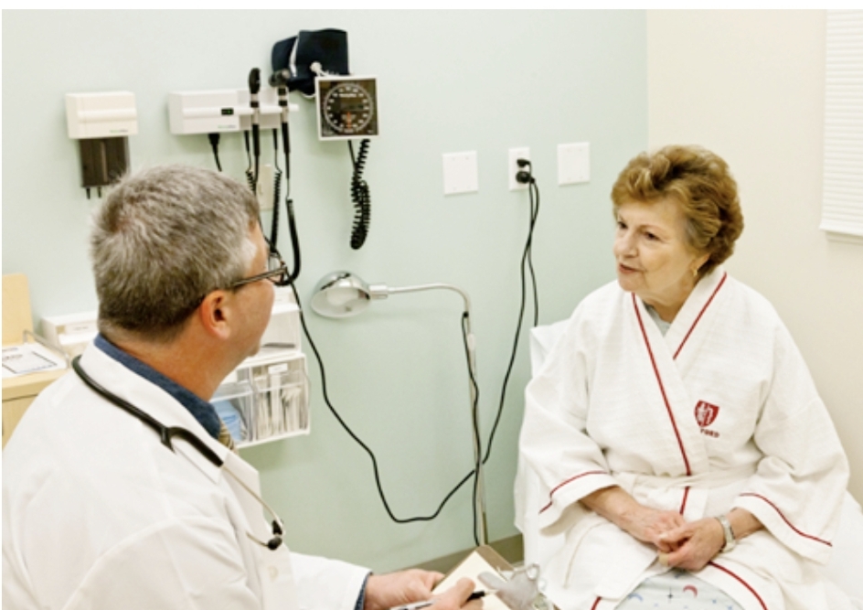 여성이 남자 의사에게 진료를 보고 있다