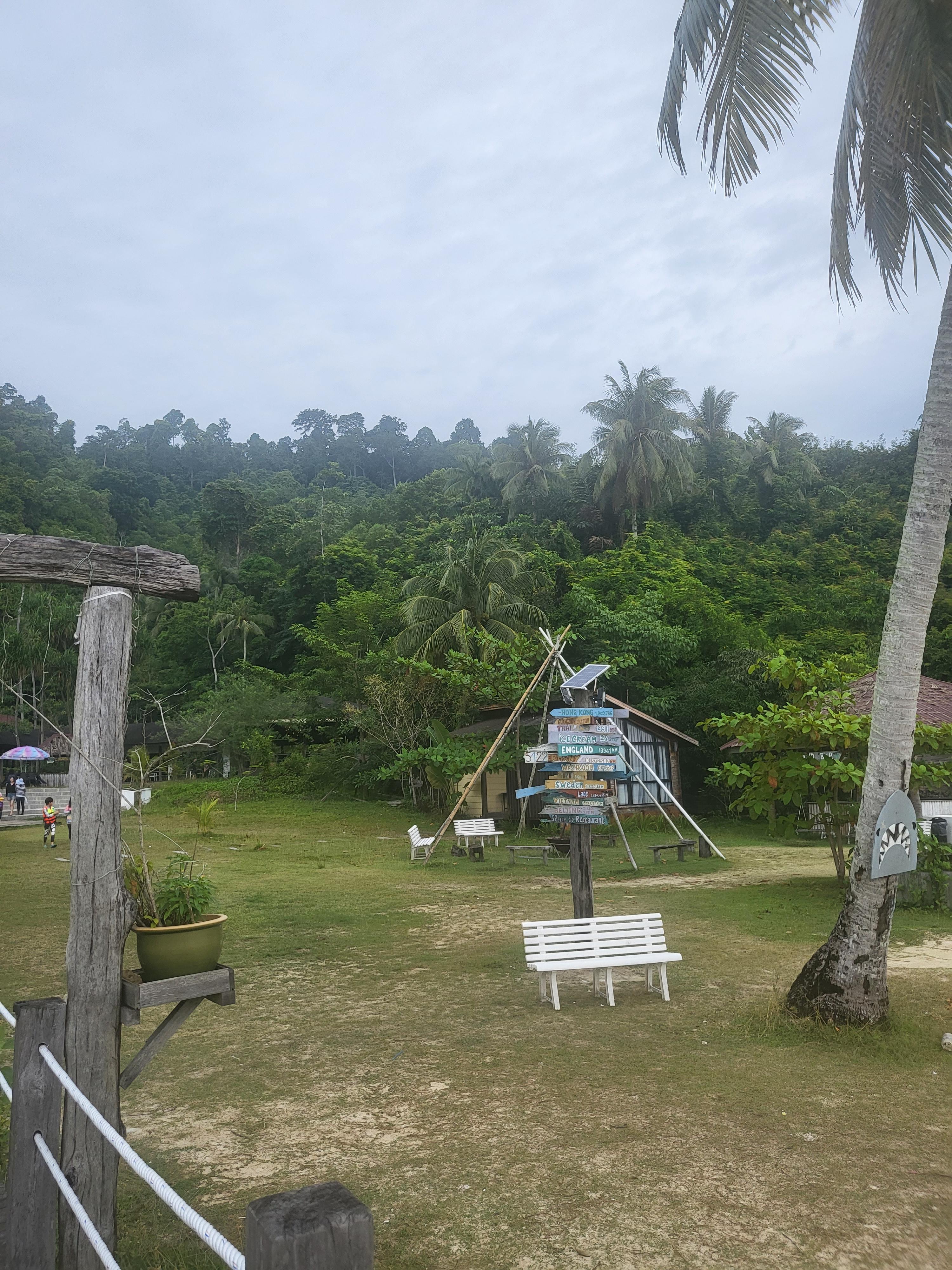 코타키나발루 섬투어 현장 풍경, 초록 숲과 표지판이 있는 여유로운 해변