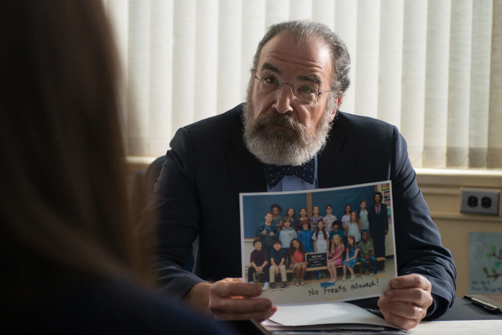 줄리언이 어기를 괴롭히는 메세지를 적은 사진을 들고 있는 교장 선생님