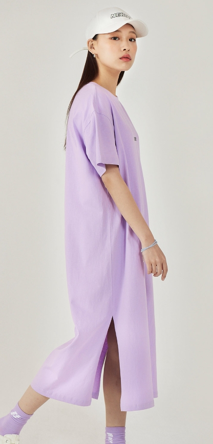 널디 원피스를 입은 여성이 서있다.