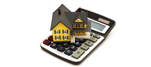 계산기위에 주택 모형이 놓여져 있음