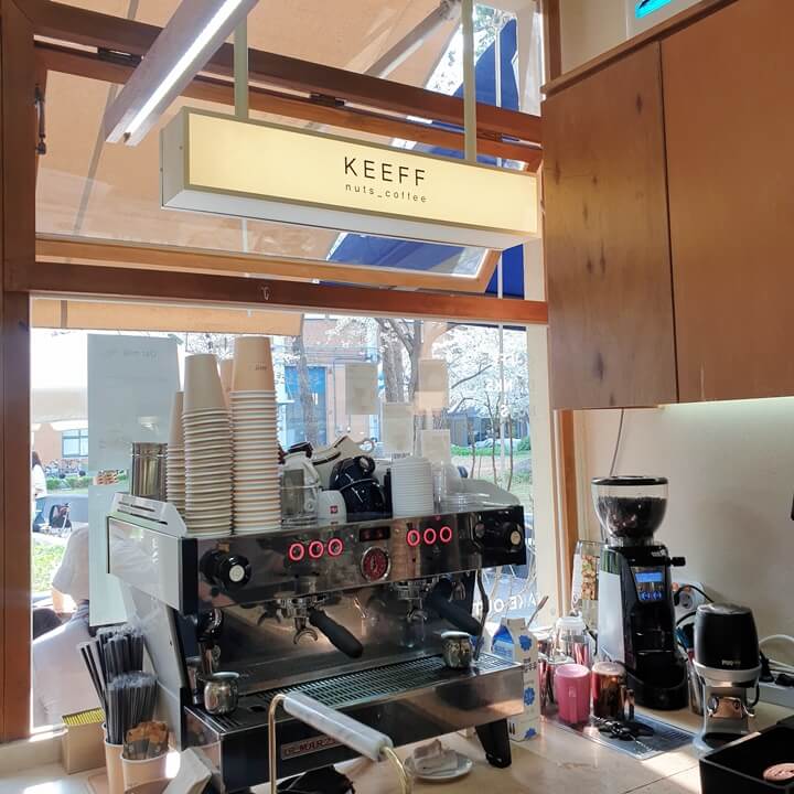 keeff간판이-카페-내부의-에스프레소머신-위에-있다