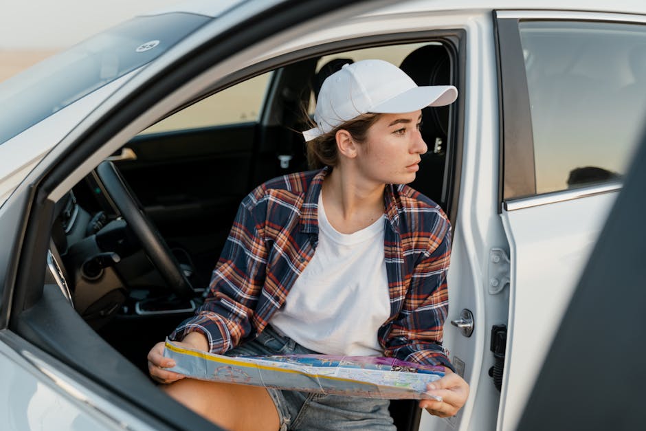 Young woman in car with map, ready for road adventure.