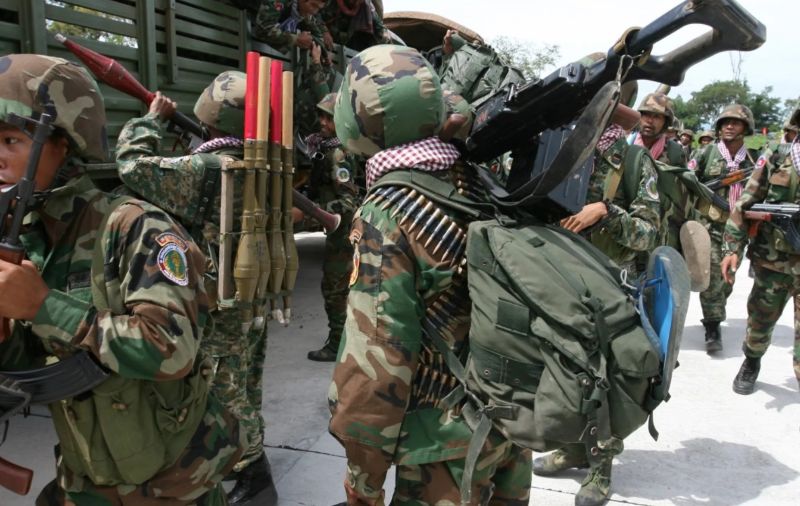 무장한 군인들이 장비를 메고 이동하는 장면