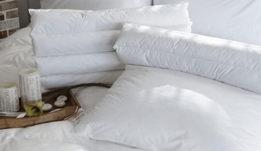 하얀색 침실의 침대가 깔끔하게 정리 되어 있다