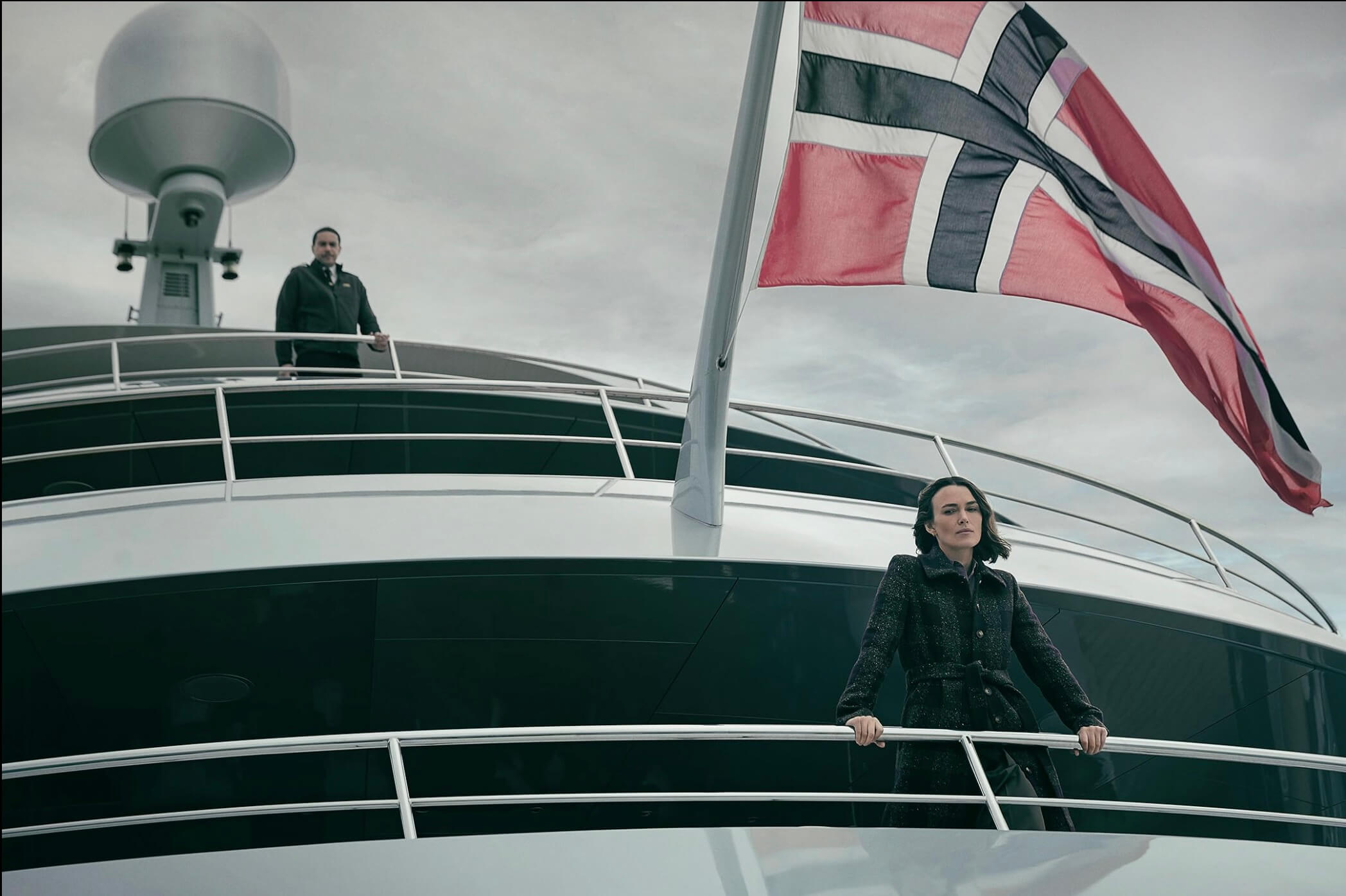 옷 속에 증거를 숨긴 채 요트 난간에서 아래를 내려다 보는 로와 위층의 난간에 있는 선장