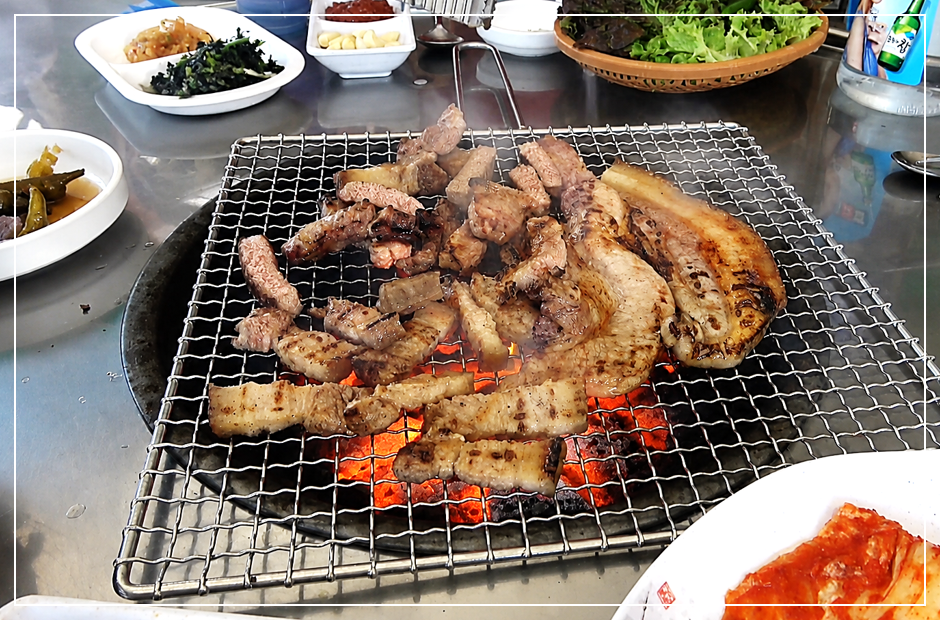 연탄불 석쇠 불판 위에서 노릇하게 익어가고 있는 지례흑돼지 왕소금구이