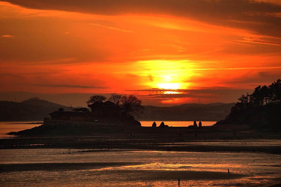 불타는 노을을 배경으로 바다위에 암자가 떠있는 아름다운 풍경