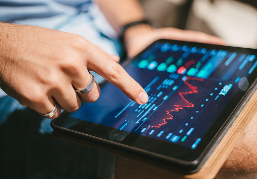태블릿 화면에서 주식 시세와 차트를 분석하는 장면