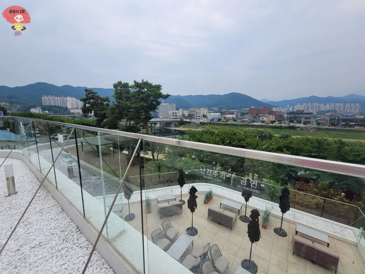 강원도-홍천-스타벅스-3층-야외테라스-빌딩과-나무숲이-보이며-2층-테라스-의자와-테이블도-보임