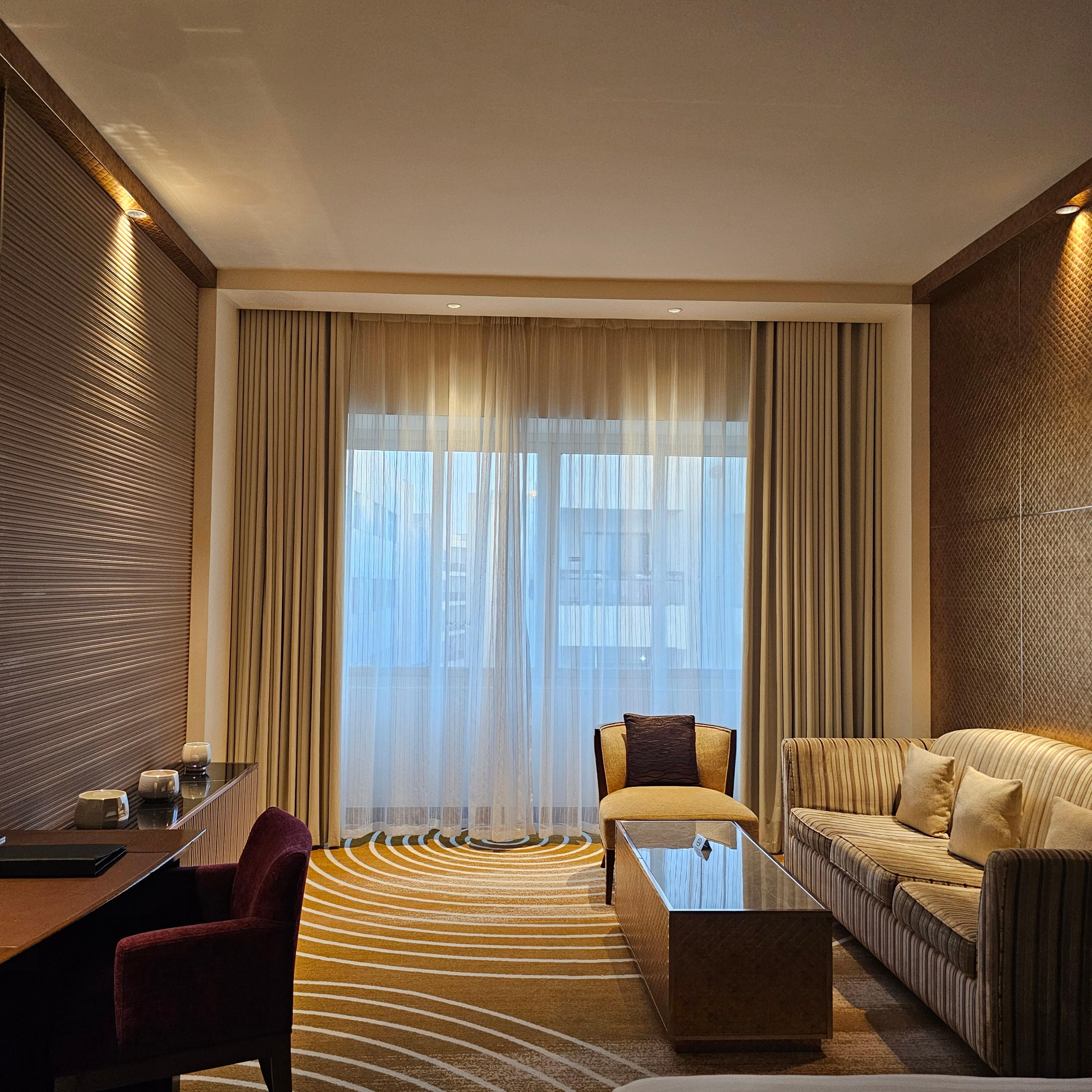 두바이 아시아나 호텔 객실 내부 침대와 소파 그리고 책상